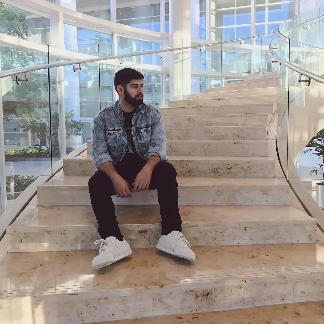 Man sitting on stairs with red Louis Vuitton X Supreme leather