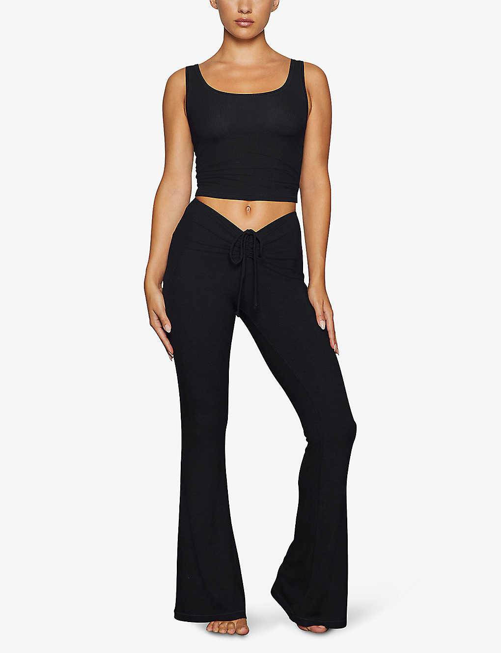 https://cms-cdn.thesolesupplier.co.uk/2023/03/skims-soft-lounge-foldover-stretch-woven-trousers-onyx-full-image.jpg