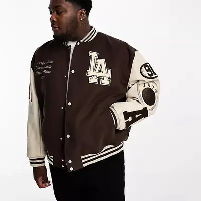 ASOS DESIGN oversized varsity bomber jacket in black with purple badging