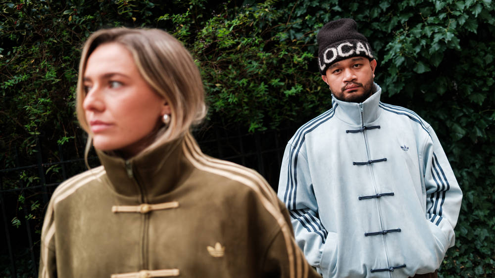 adidas Tang jacket green and blue colour styled against outdoor backdrop