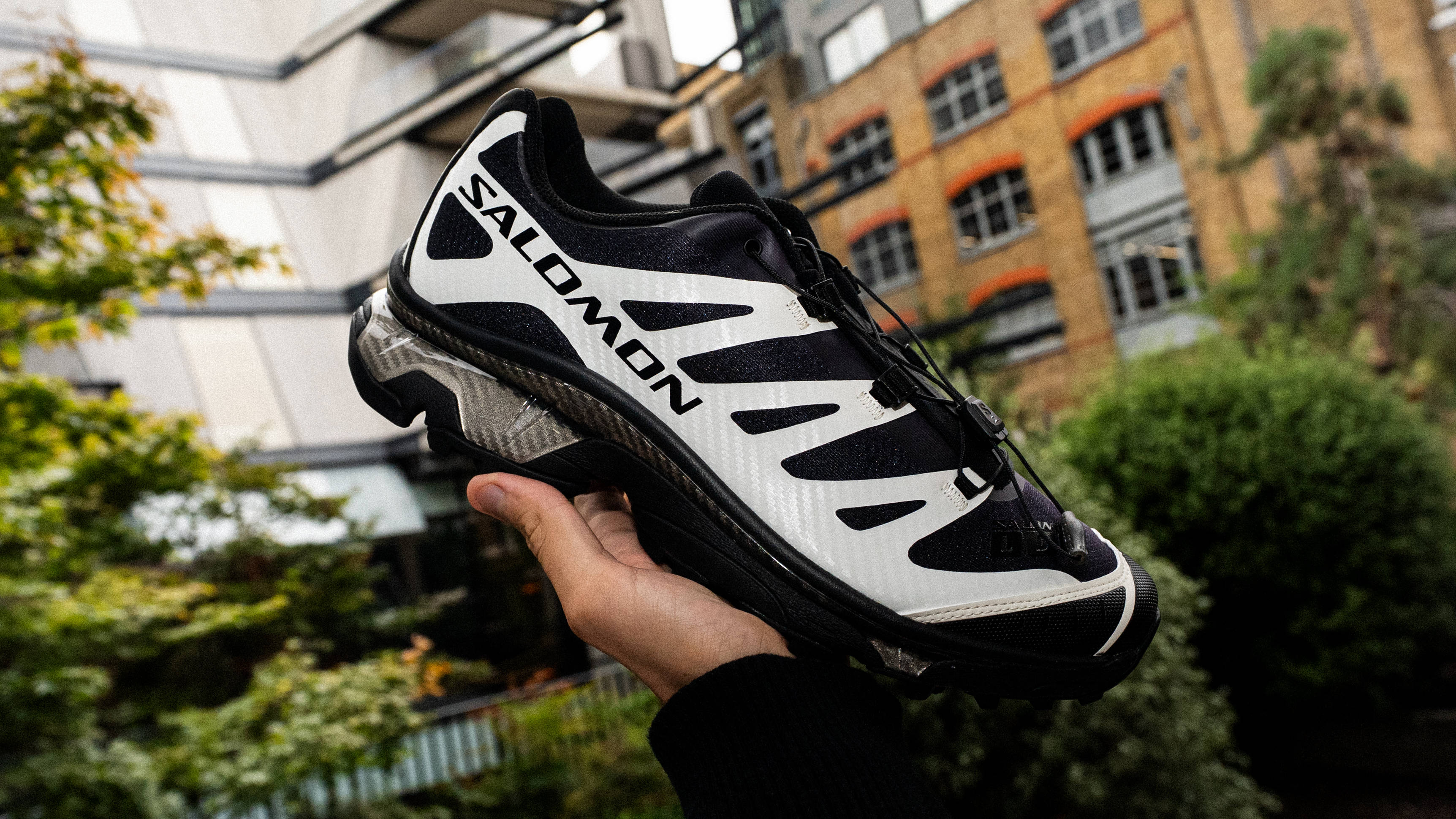 Footpatrol x Salomon XT-4 Black Vanilla Ice in-hand with london city scape in background