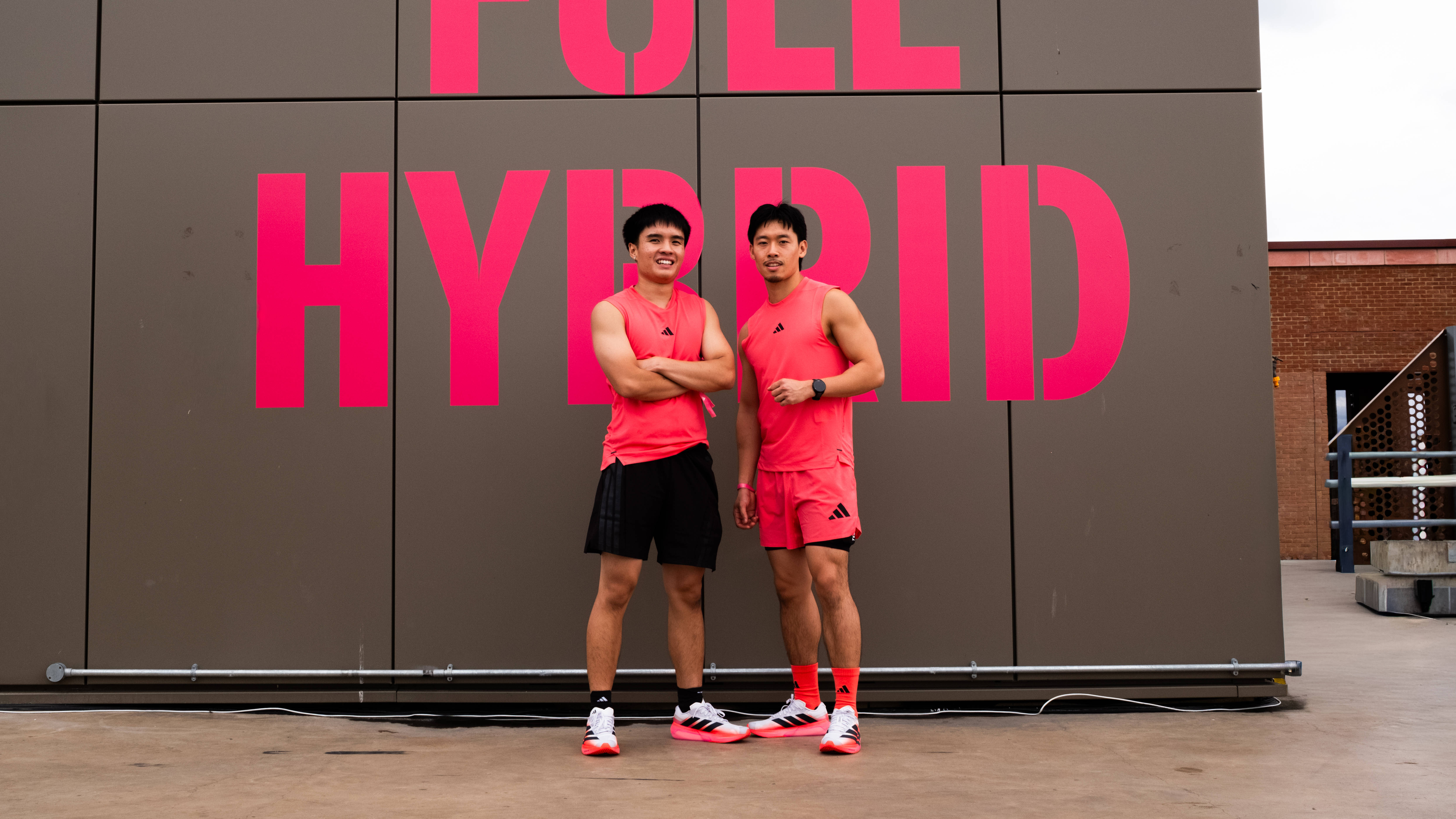 two male athletes standing in front of adidas' GO FULL HYBRID activation