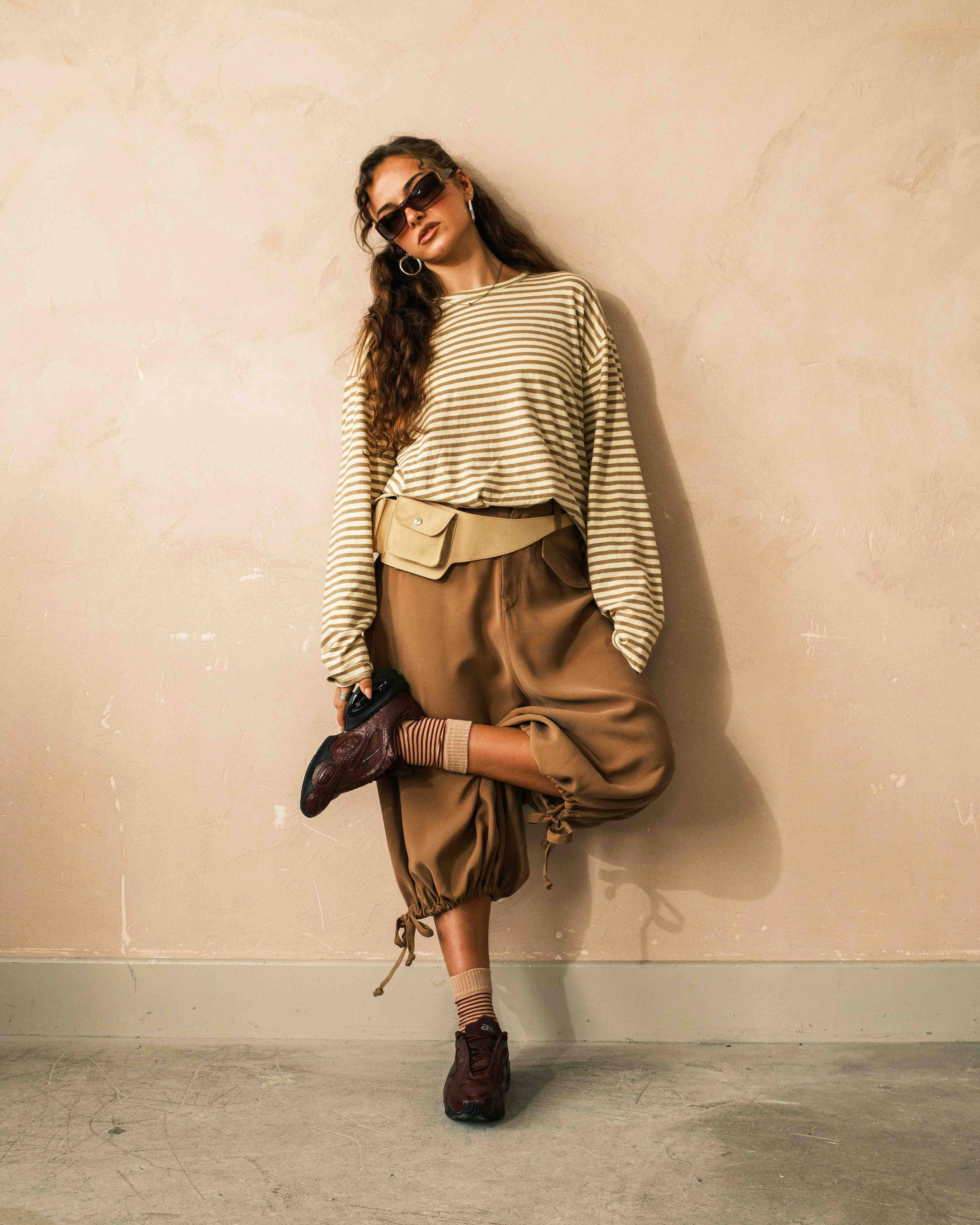 outfit 3 full fit air max muse styled against begie wall shot editorial