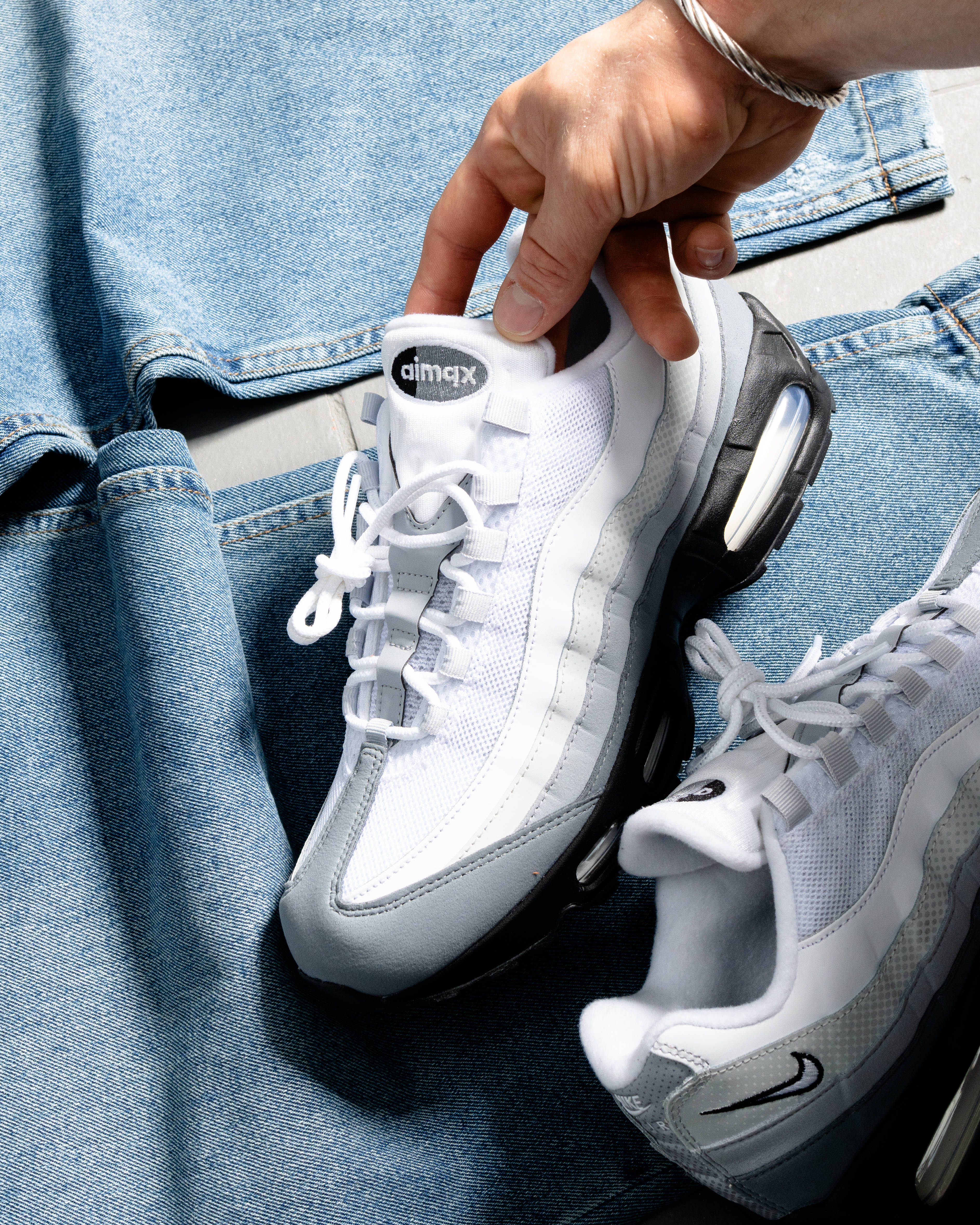 air max 95 paired against baggys light denim wash jean laid flat