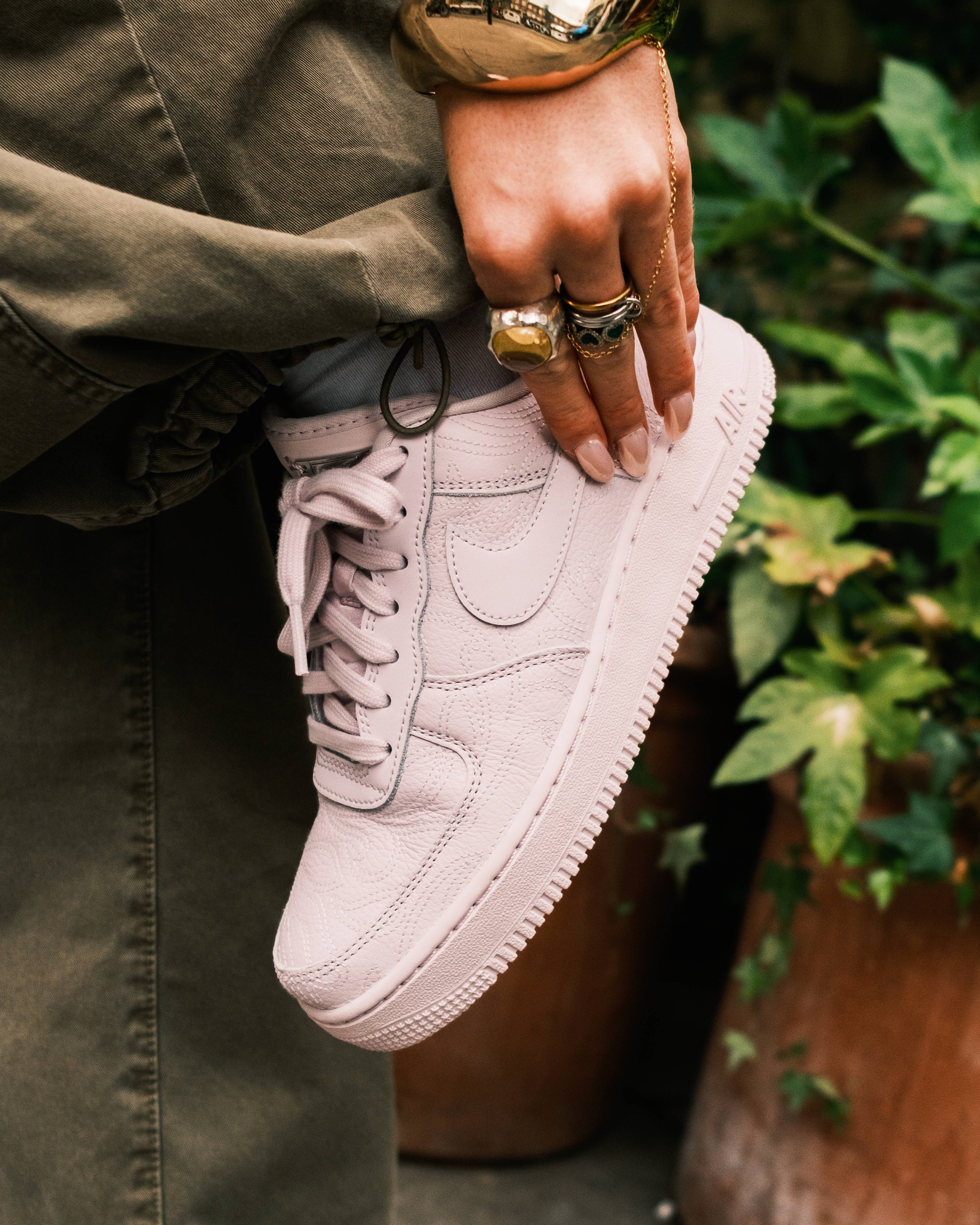 air force 1 shoe on hand jewellry gold styled editorial