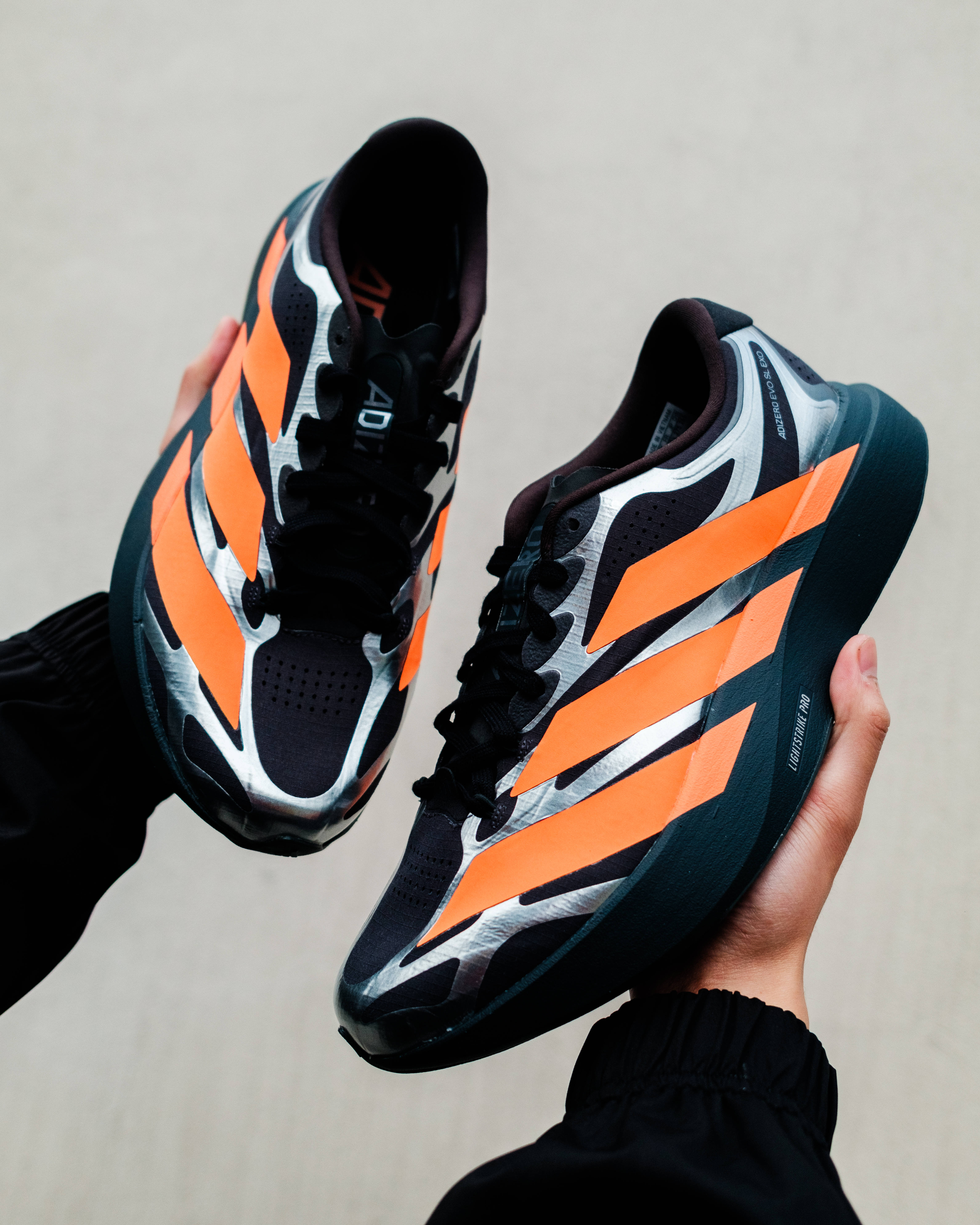 adidas evo sl exo carbon lucid orange in-hand editorial images