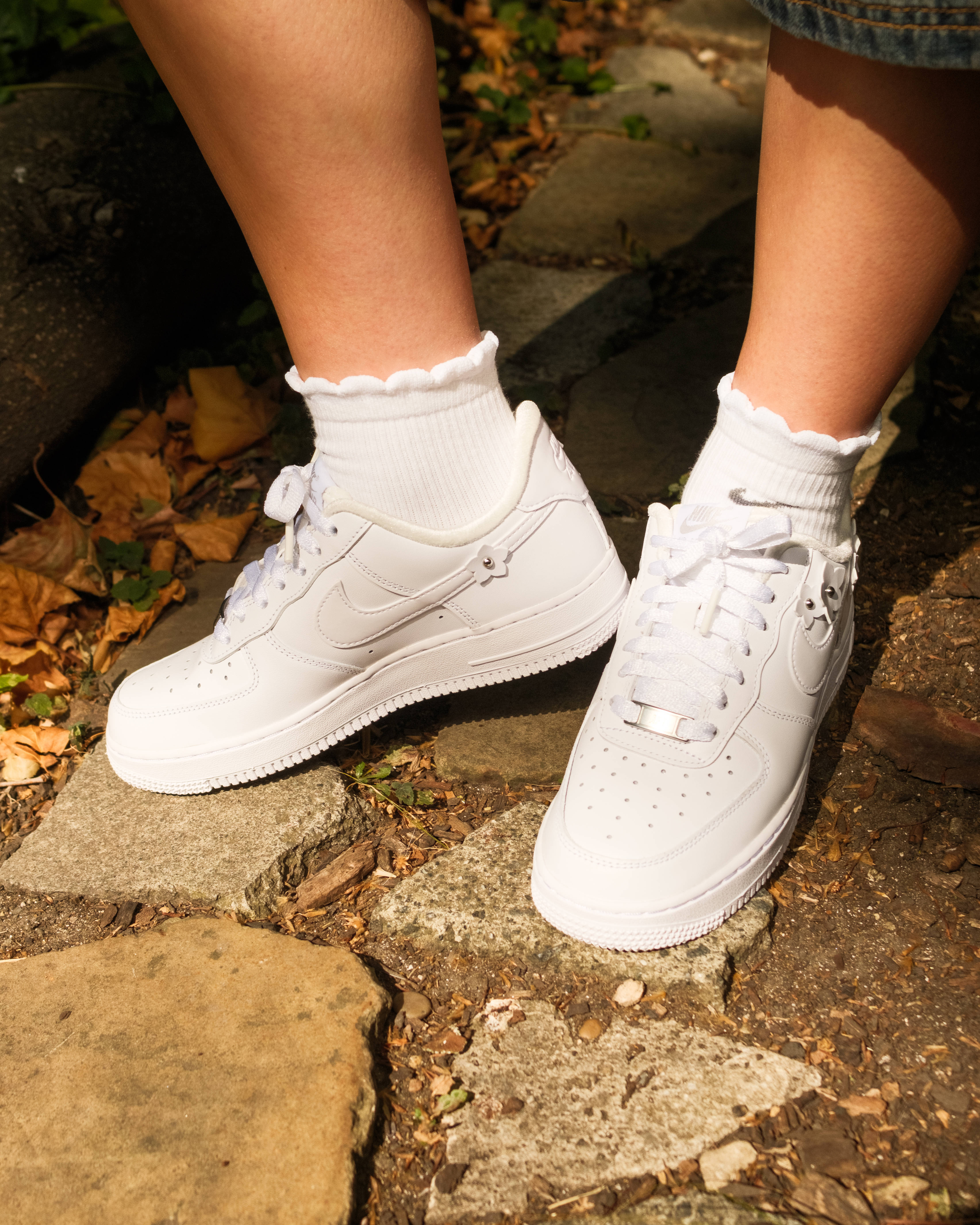 air force 1 femme floral details editorial sunlight shining on trainers stone backdrop