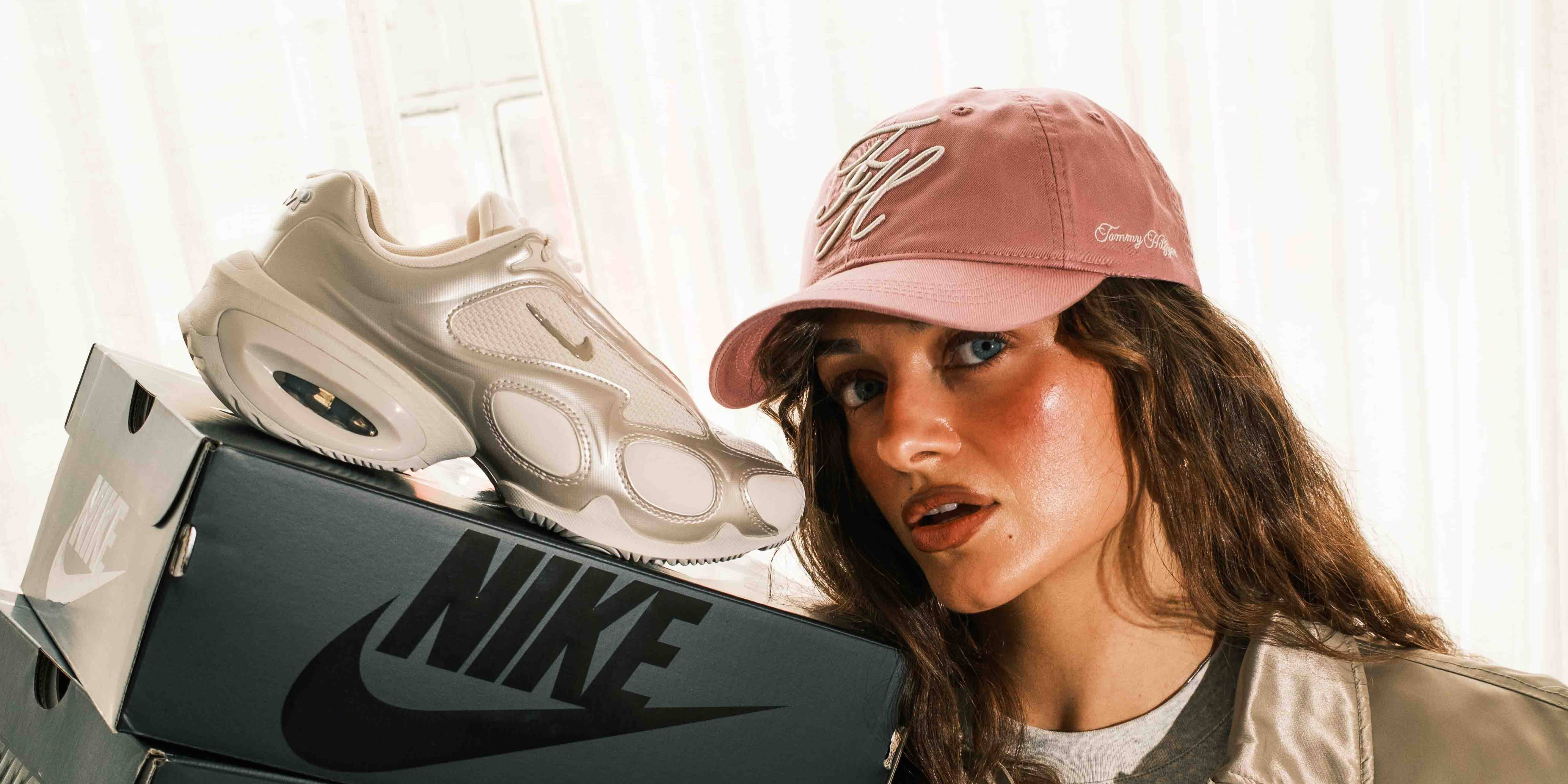 nike air max muse chalk colourway close up next to face on top of stack of nike boxes