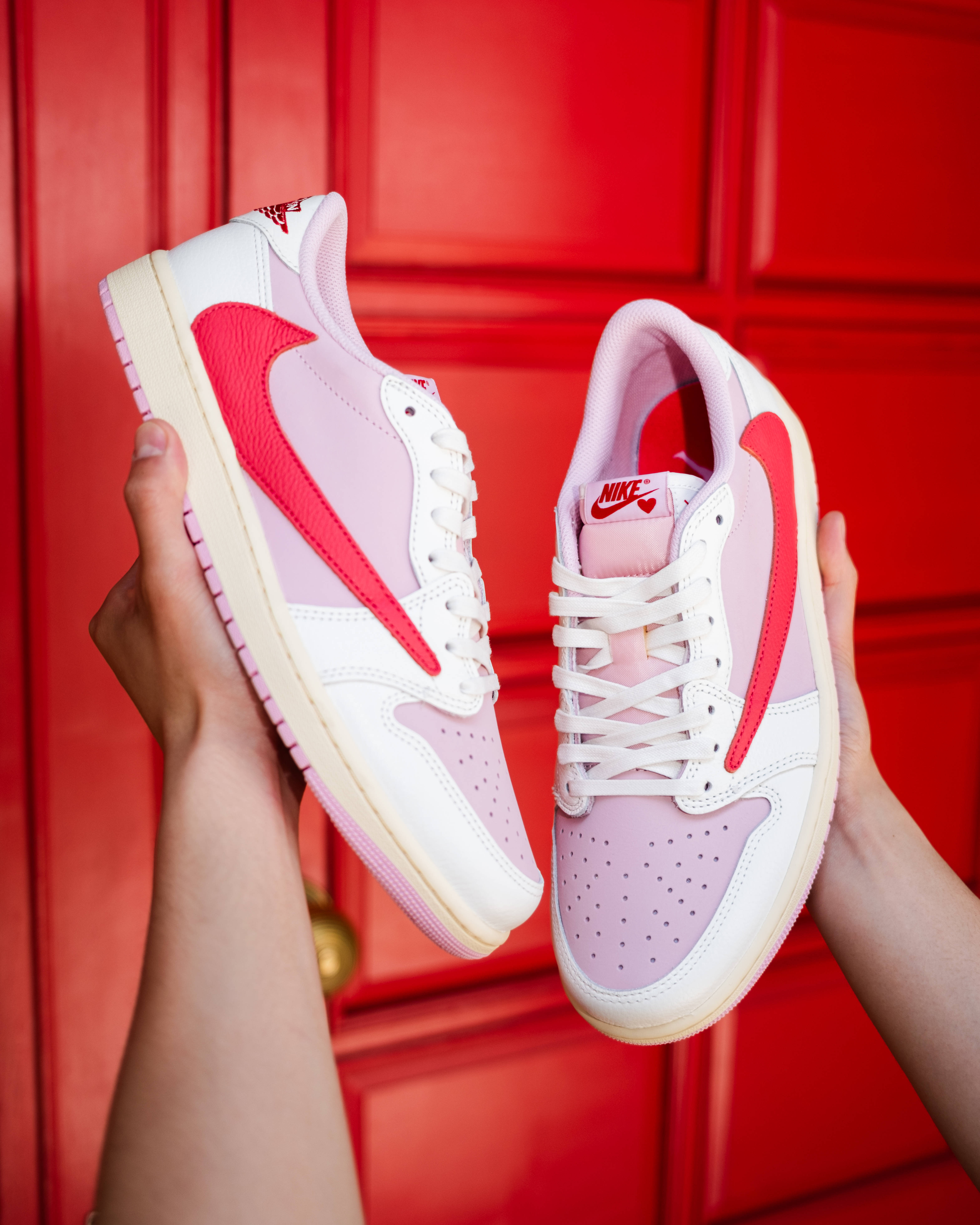 shy pink travis jordan 1 low in hand