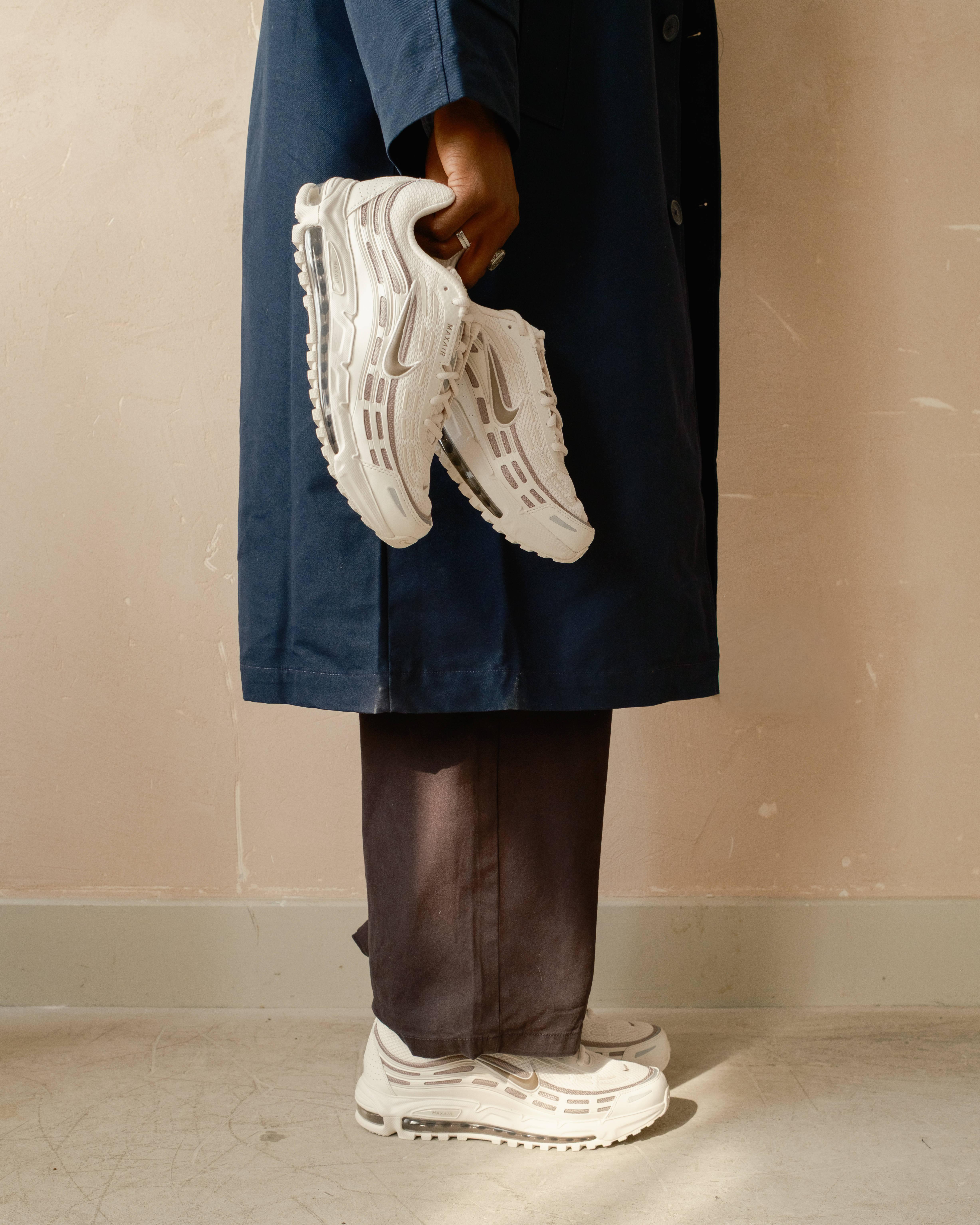 nike air max tl 2.5 phantom colourway on feet and in hand shot with rustic backdrop