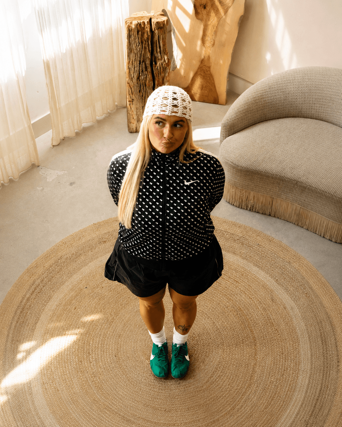 off duty polka dott nike jacket and skirt paired with netted hat and nike moon shoes in green top down shot of model