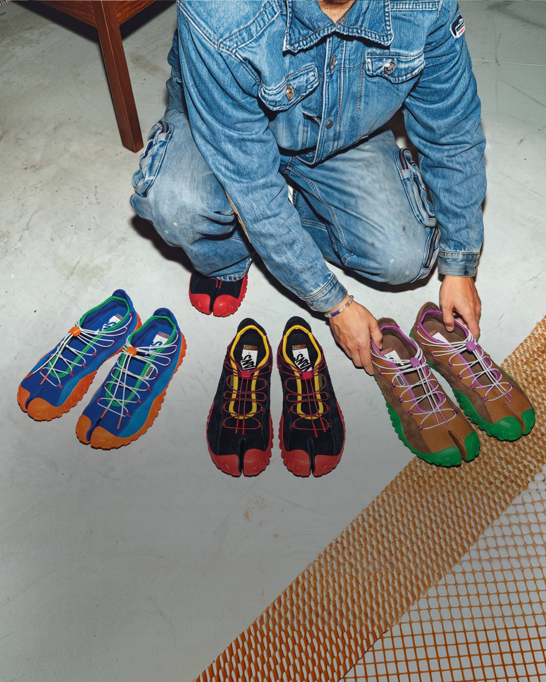 sza x vans tabis out on display all 3 pairs with a guy in denim two piece laying them out on concrete floor