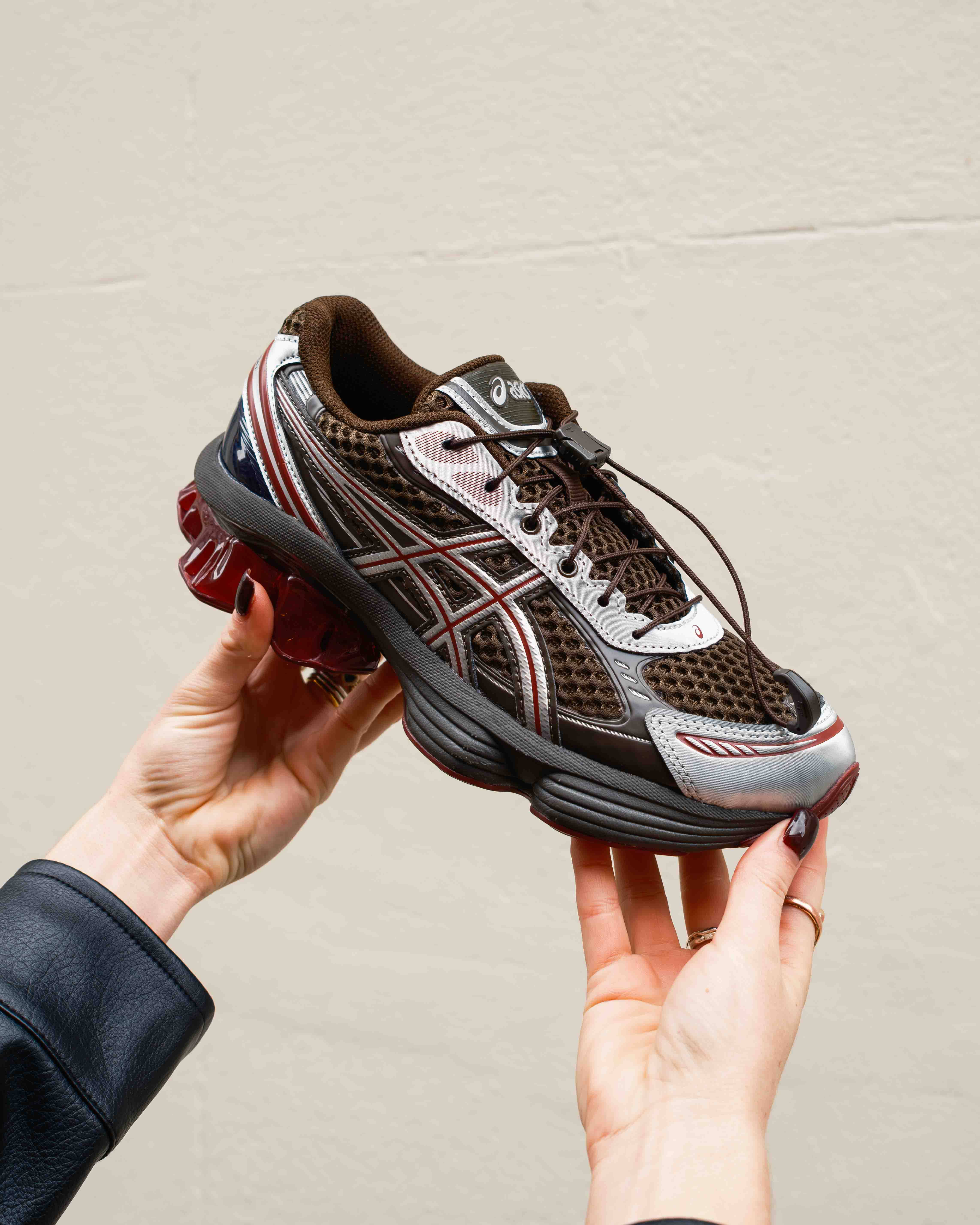 asics gel kinetic in hand shots against white wall