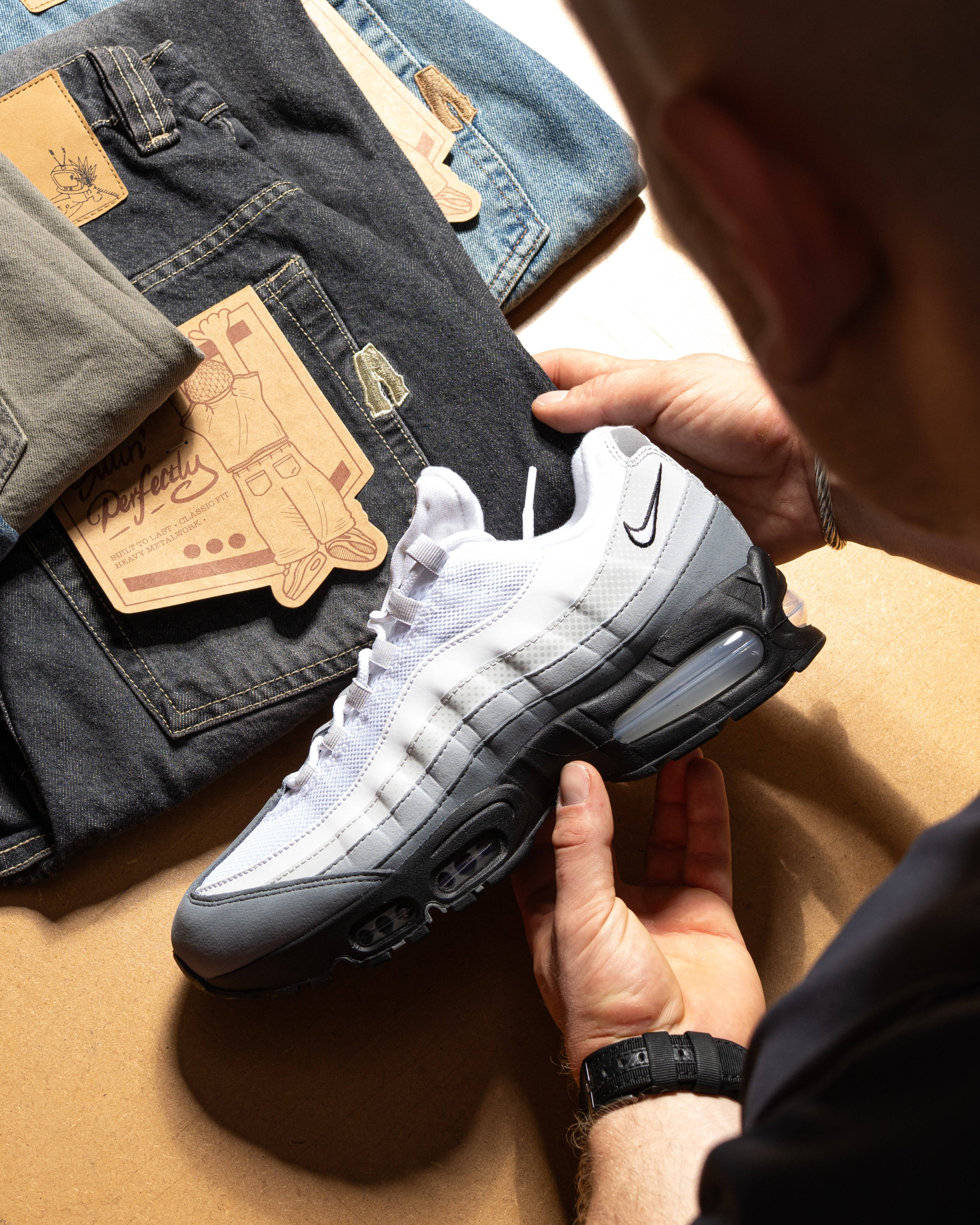 air max 95 held against folded denim to find pairing out 