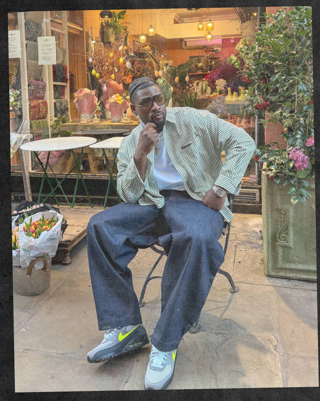 male model wearing Nike air max 90 neon sat down in baggy denim and camo jacket