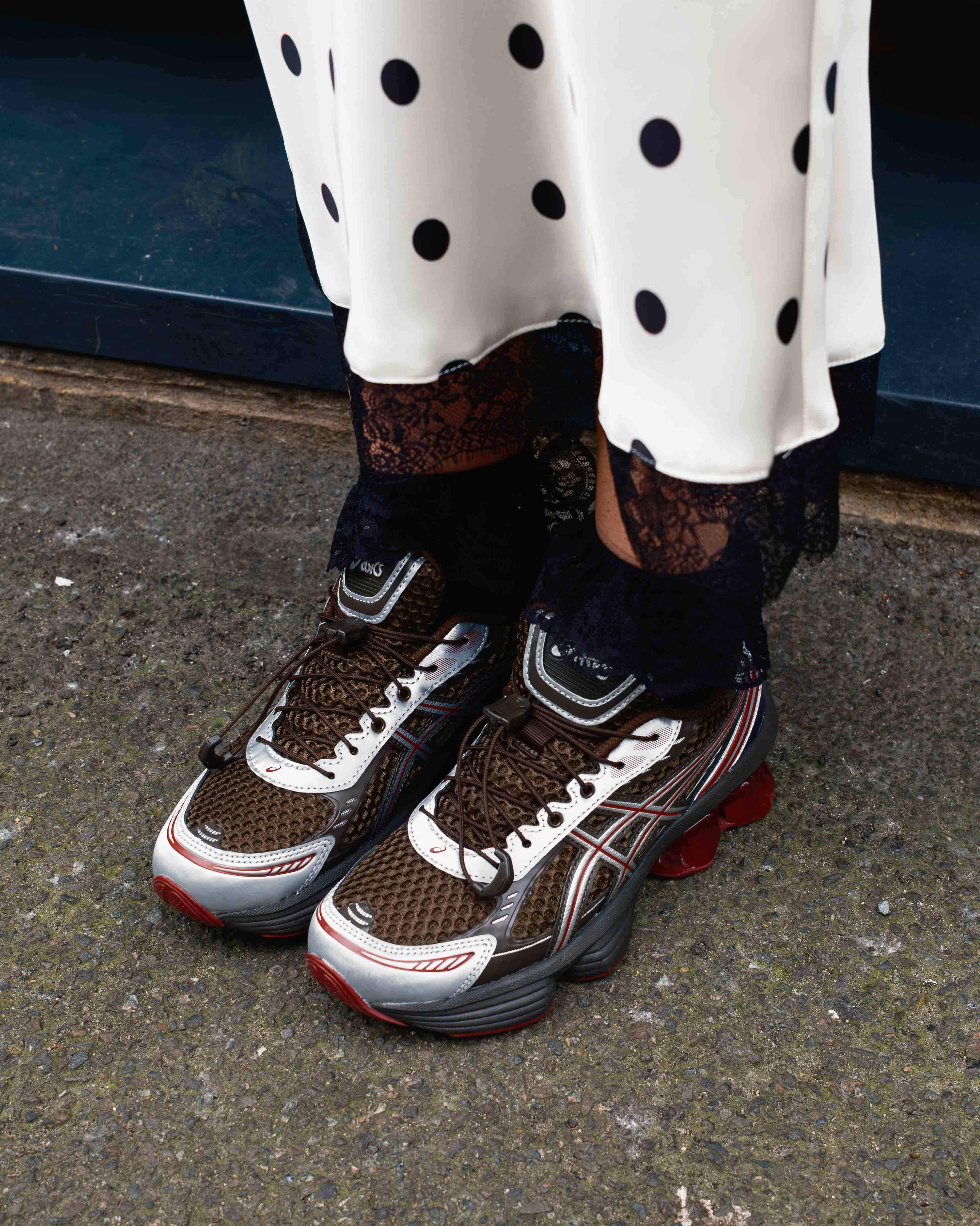 asics gel-kinetic on feet with pavement backdrop