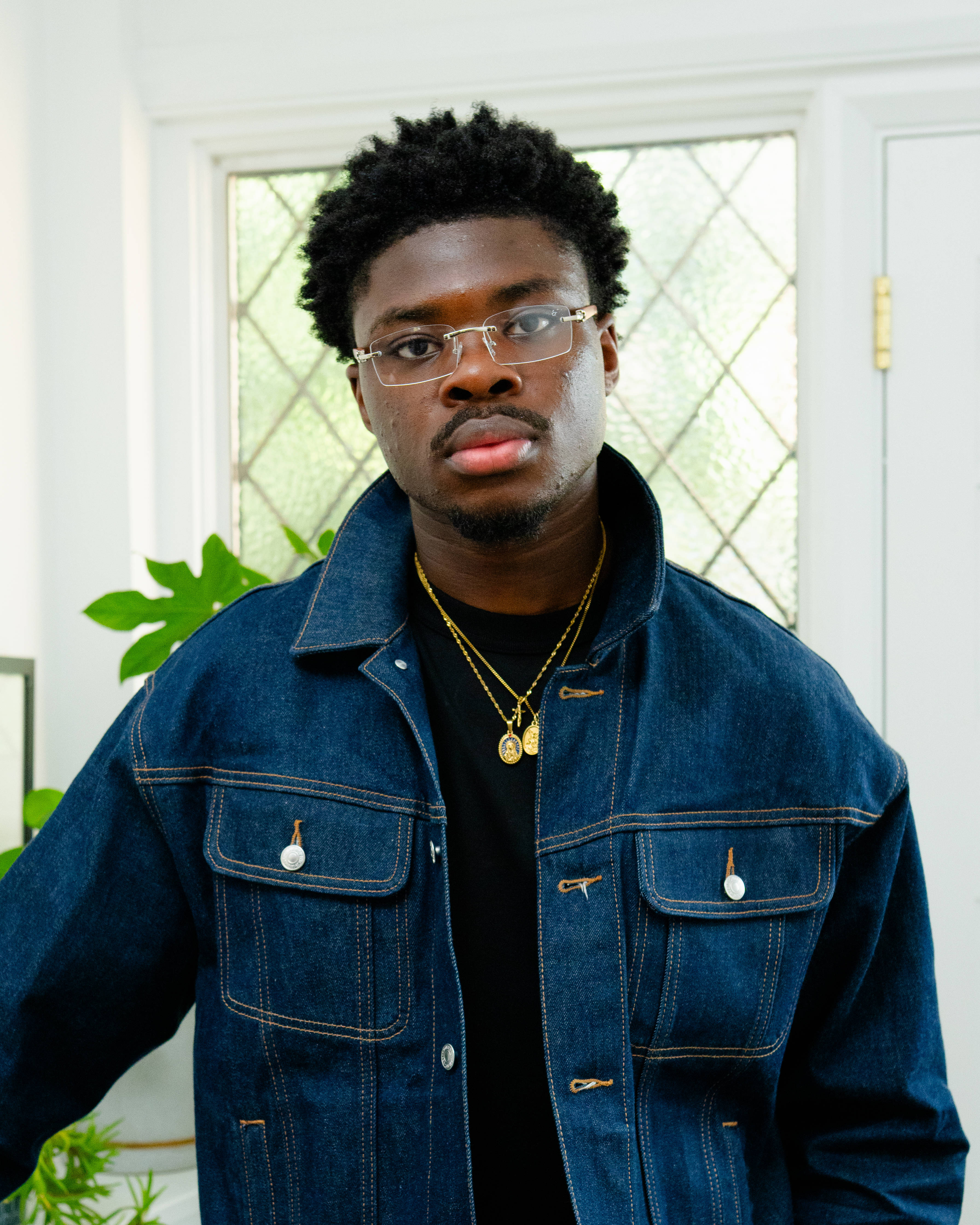denim trucker jacket glasses and chain accessories for editorial men's date night fit studio lighting house entrance backdrop