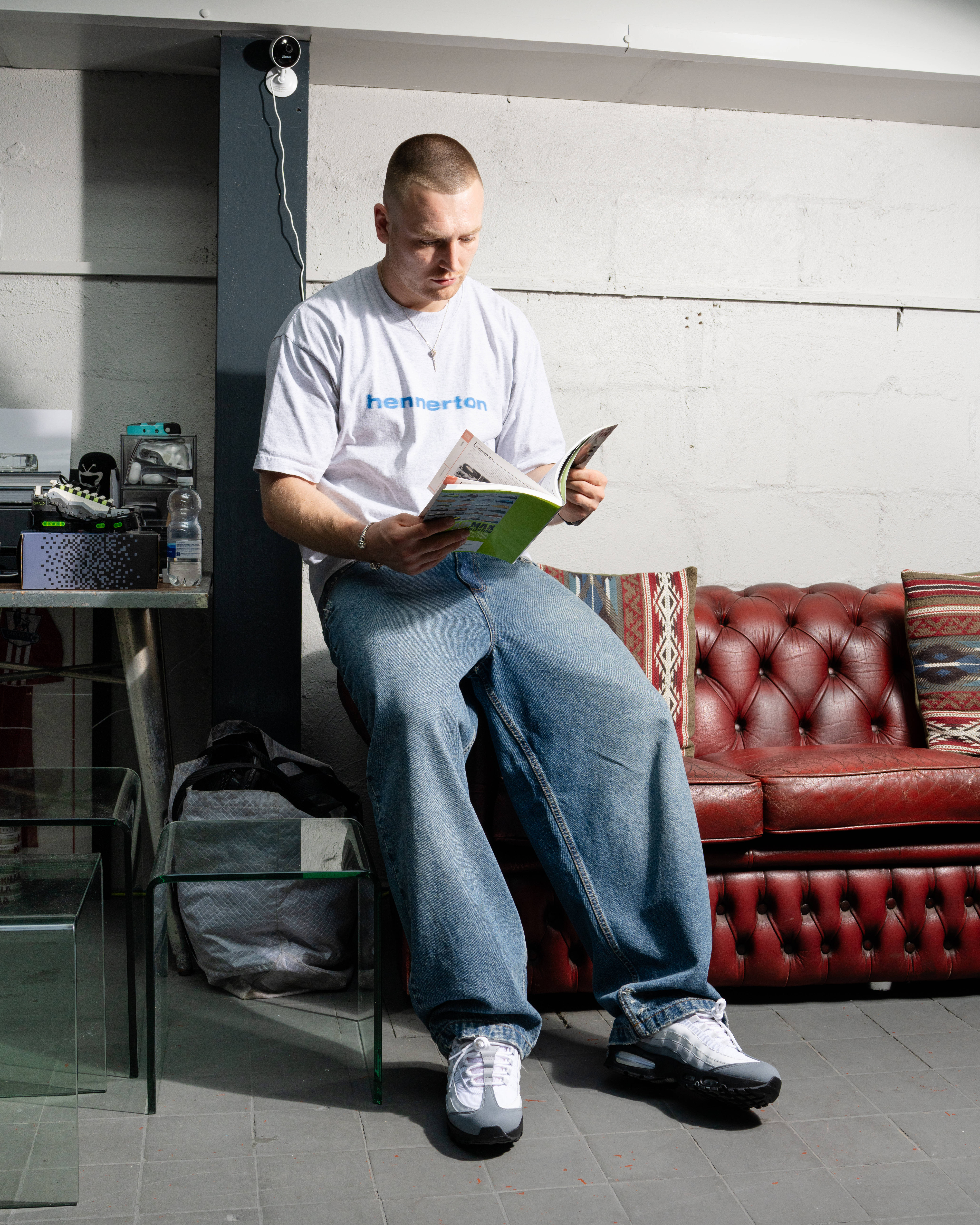 baggys.tv's Red sat on couch in studio reading magazine editorial