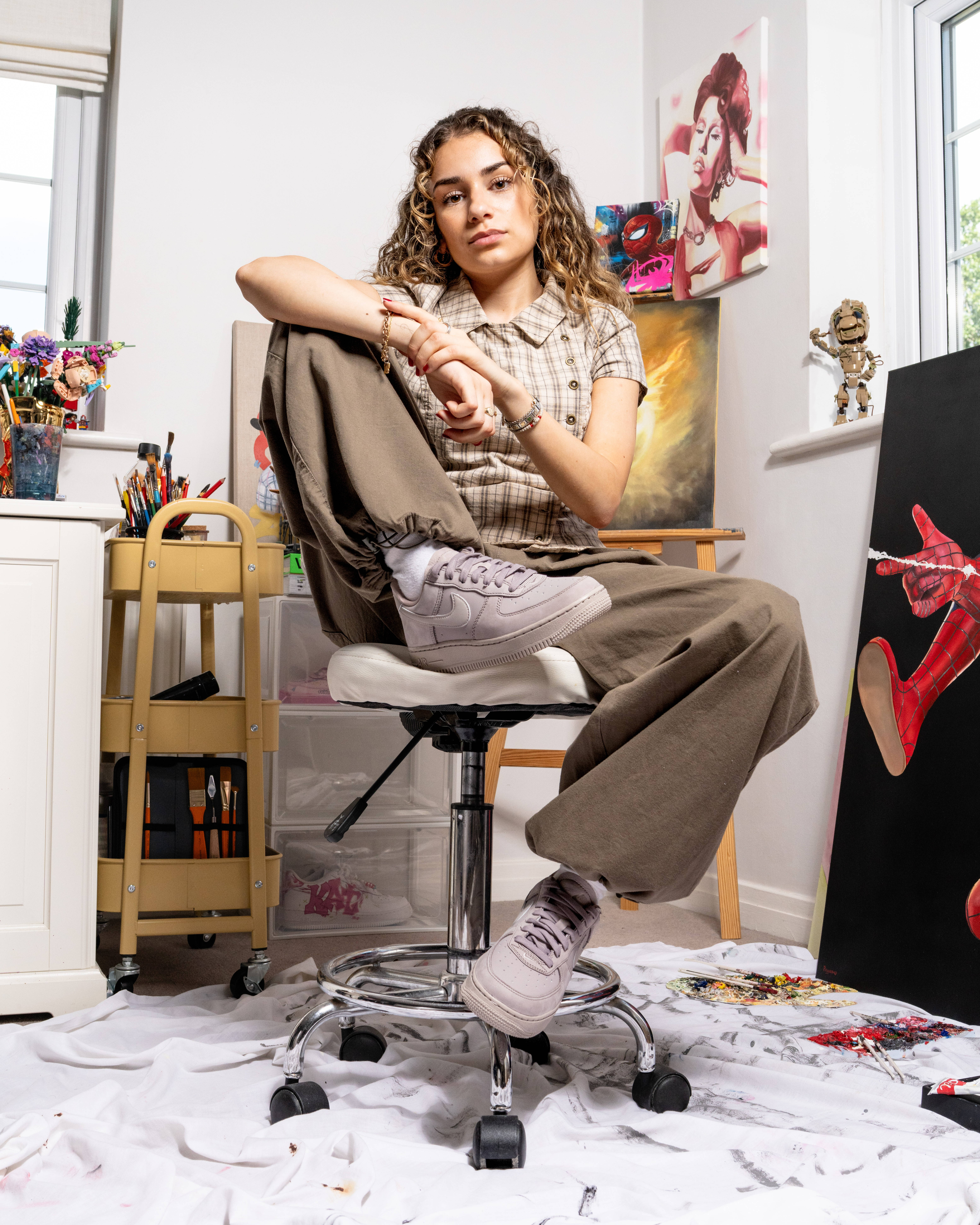 emilia poyiadgi holding up air force 1 pink custom pair in her studio