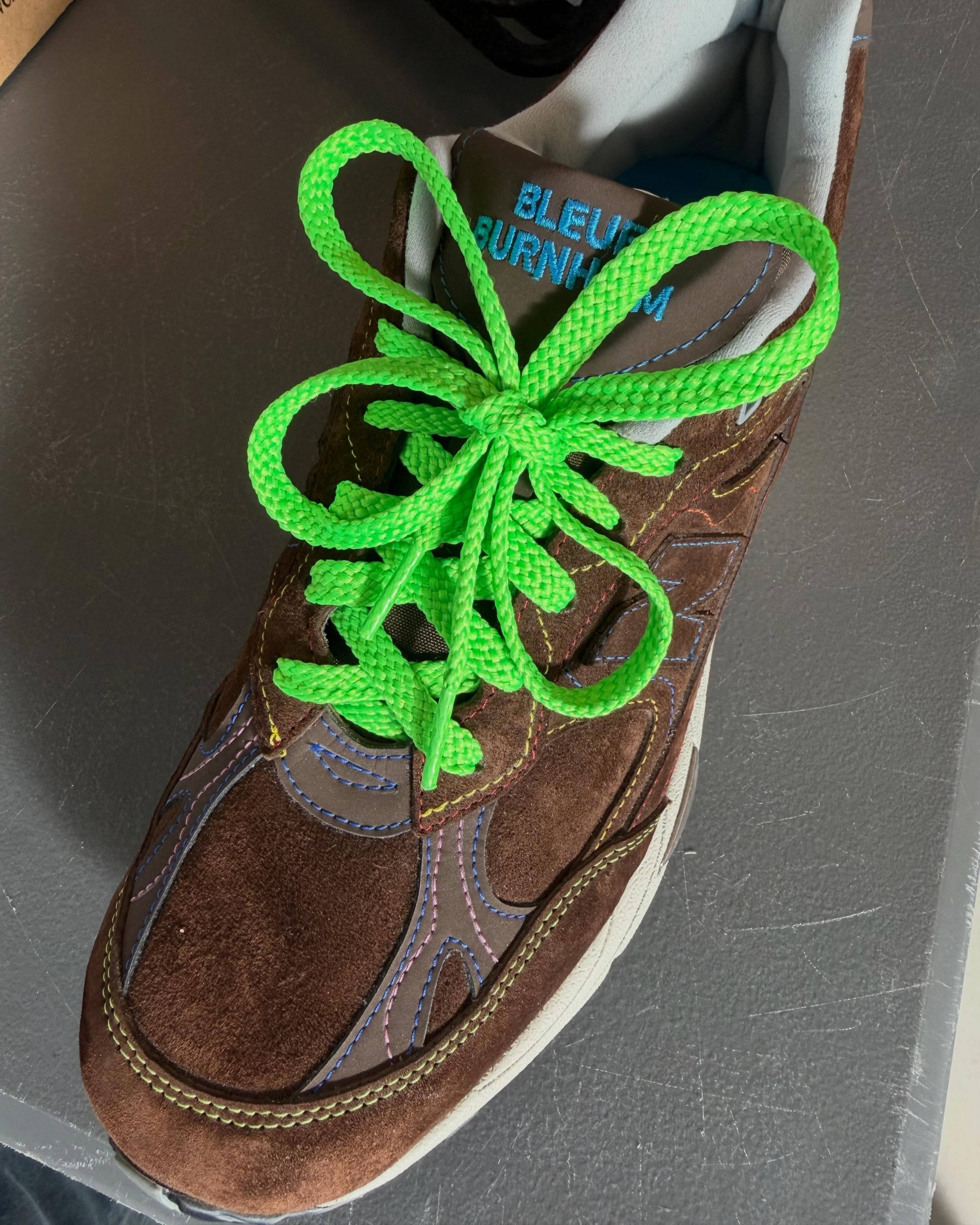 top down angled shot of the bleue burnham x nb 991 forefoot with different bright green laces