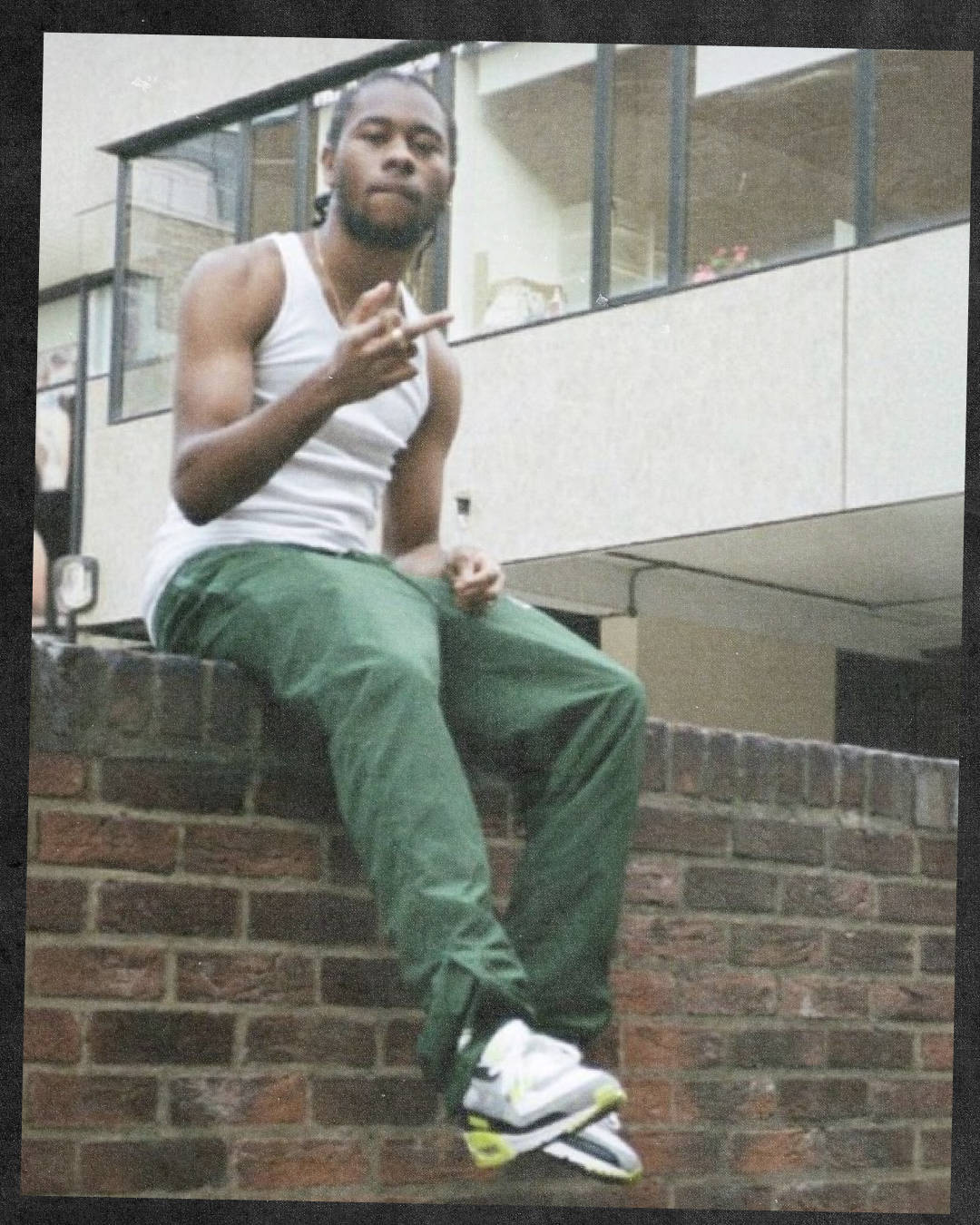 clint from corteiz sat on brick wall wearing the neon yellow Nike Air Max 90 from 2020